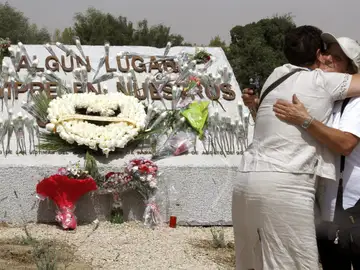 Familiares de las víctimas se abrazan ante la piedra de granito conmemorativa levantada en el lugar donde se produjo el accidente Familiares de las víctimas se abrazan ante la piedra de granito conmemorativa levantada en el lugar donde se produjo el accidente