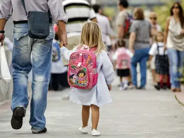 Padre que acompaña a su hija al colegio Padre que acompaña a su hija al colegio