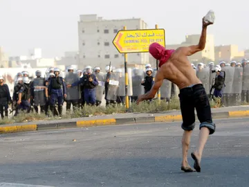 Un manifestante lanza un objeto a la policía Un manifestante lanza un objeto a la policía