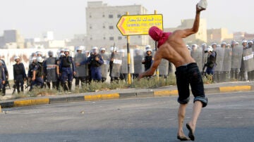 Un manifestante lanza un objeto a la policía