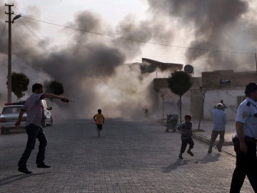 Unos ciudadanos turcos escapan del humo provocado por el estallido de una bomba de mortero lanzada en Sanliurfa Unos ciudadanos turcos escapan del humo provocado por el estallido de una bomba de mortero lanzada en Sanliurfa