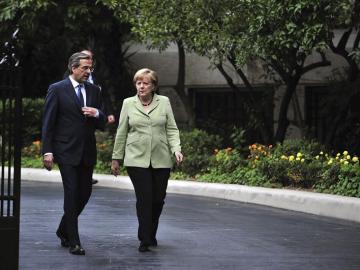 El primer ministro Griego, Andonis Samarás, camina junto a la canciller alemana, Angela Merkel