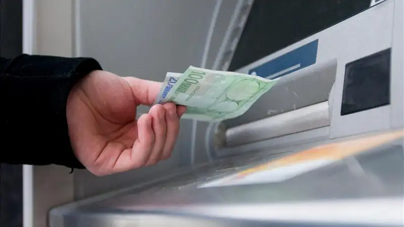 Un hombre saca dinero de un cajero Un hombre saca dinero de un cajero