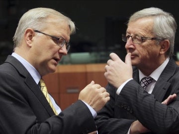 El presidente del Eurogrupo, Jean-Claude Juncker, conversa con el vicepresidente económico de la Comisión Europea, Olli Rehn.