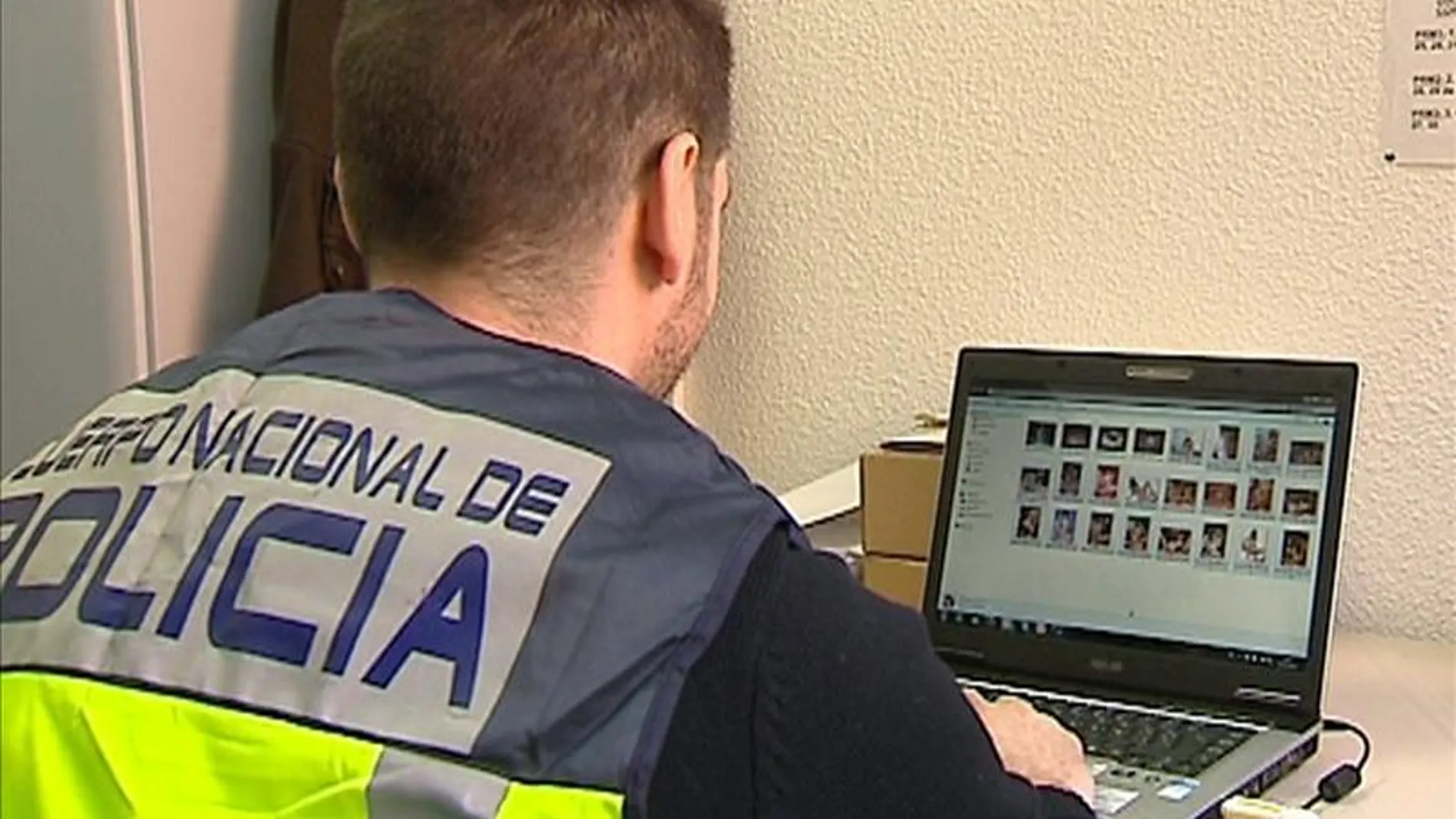 Un policía comprueba archivos de pornografía en un ordenador Un policía comprueba archivos de pornografía en un ordenador