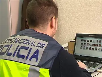 Un policía comprueba archivos en un ordenador Un policía comprueba archivos en un ordenador