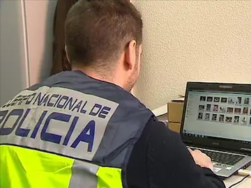 Un policía comprueba archivos en un ordenador Un policía comprueba archivos en un ordenador
