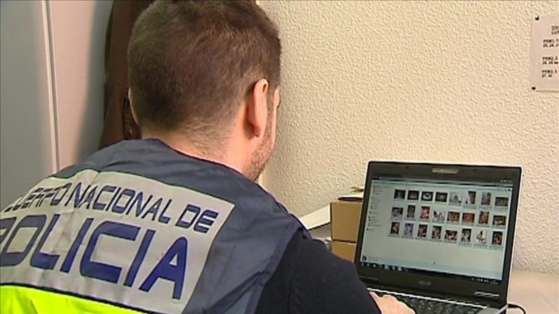 Un policía comprueba archivos en un ordenador Un policía comprueba archivos en un ordenador
