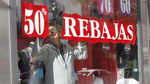 Un vendedor prepara un escaparate para las rebajas Un vendedor prepara un escaparate para las rebajas