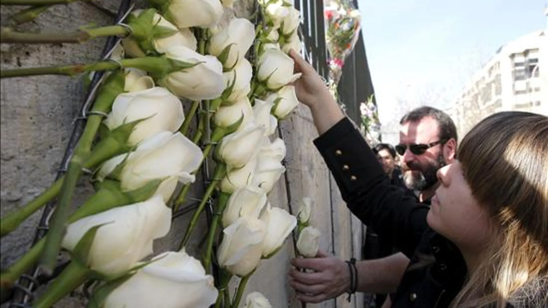 Un centenar de familias coloca 191 rosas blancas