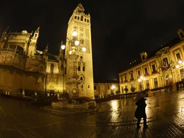 Una mujer se protege de la lluvia registrada en Sevilla Una mujer se protege de la lluvia registrada en Sevilla
