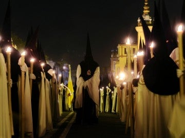 Un grupo de nazarenos en una procesión de la Semana Santa de Sevilla