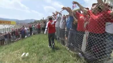 Alonso se baja del coche del 'drivers parade' y saluda a la afición