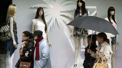 Varias mujeres se protegen de la lluvia y del fr&iacute;o registrado en Pamplona