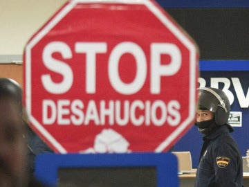 Cartel de "Stop Desahucios" delante de una sucursal del BBVA.