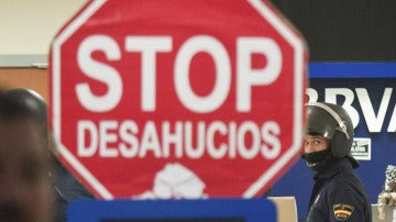 Cartel de "Stop Desahucios" delante de una sucursal del BBVA.