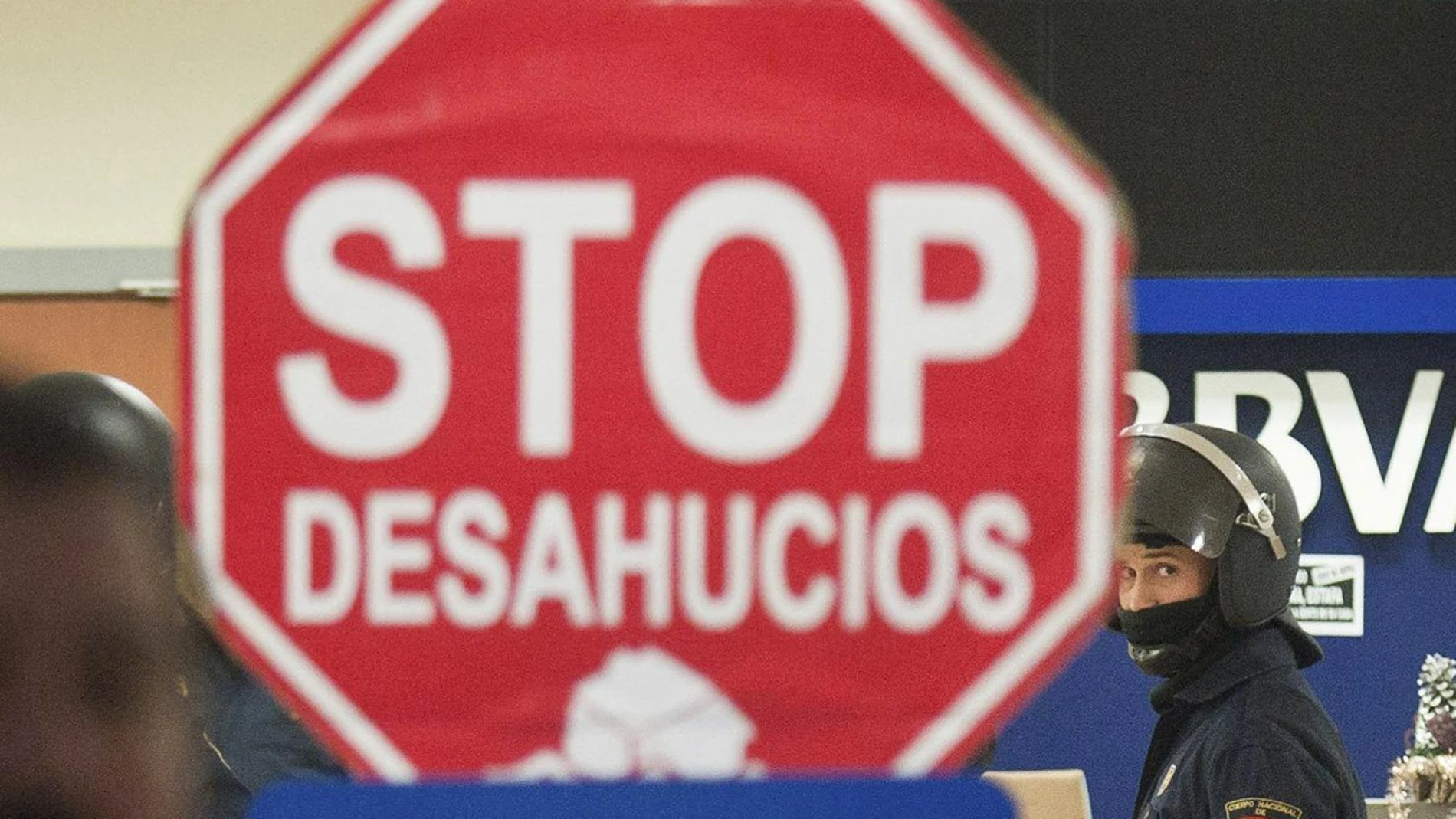 Cartel de "Stop Desahucios" delante de una sucursal del BBVA. Cartel de "Stop Desahucios" delante de una sucursal del BBVA.