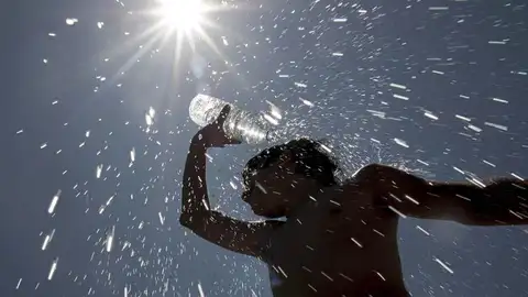 Un trabajador de parques y jardines de Badajoz se refresca bajo un intenso sol Un trabajador de parques y jardines de Badajoz se refresca bajo un intenso sol