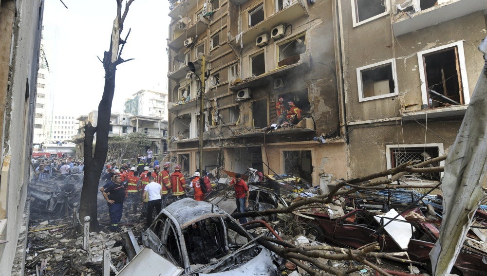 Bomberos libaneses apagan el incendio ocasionado en un edificio por la explosión del coche bomba, en Beirut