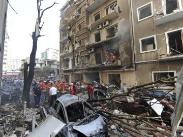 Bomberos libaneses apagan el incendio ocasionado en un edificio por la explosión del coche bomba, en Beirut
