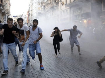Manifestantes corren ante los cañones de agua de la policía turca