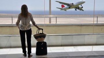 Una joven con su maleta espera en el aeropuerto