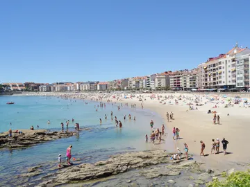 Con el día soleado la gente disfrutaba de la playa Con el día soleado la gente disfrutaba de la playa