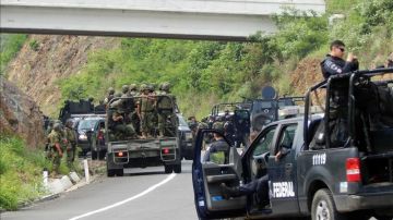 Agentes federales y soldados del Ejército mexicano resguardan una carretera