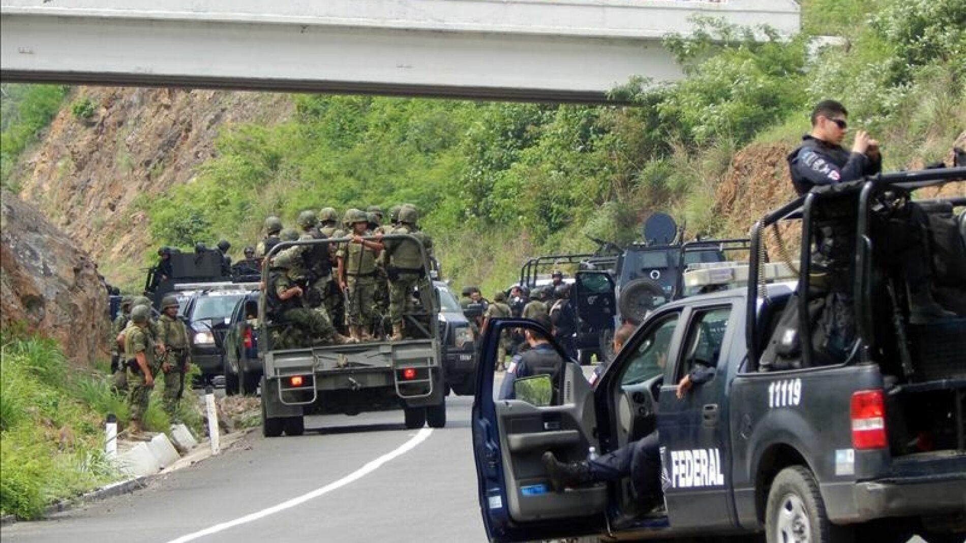 Agentes federales y soldados del Ej&eacute;rcito mexicano resguardan una carretera