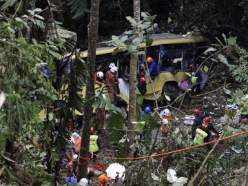 Los servicios de emergencias asisten a los heridos del accidente de autobús en Malasia.