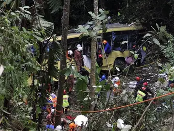 Los servicios de emergencias asisten a los heridos del accidente de autobús en Malasia. Los servicios de emergencias asisten a los heridos del accidente de autobús en Malasia.