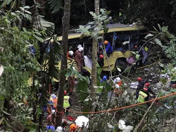 Los servicios de emergencias asisten a los heridos del accidente de autobús en Malasia. Los servicios de emergencias asisten a los heridos del accidente de autobús en Malasia.