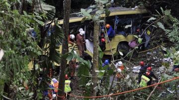 Los servicios de emergencias asisten a los heridos del accidente de autobús en Malasia.