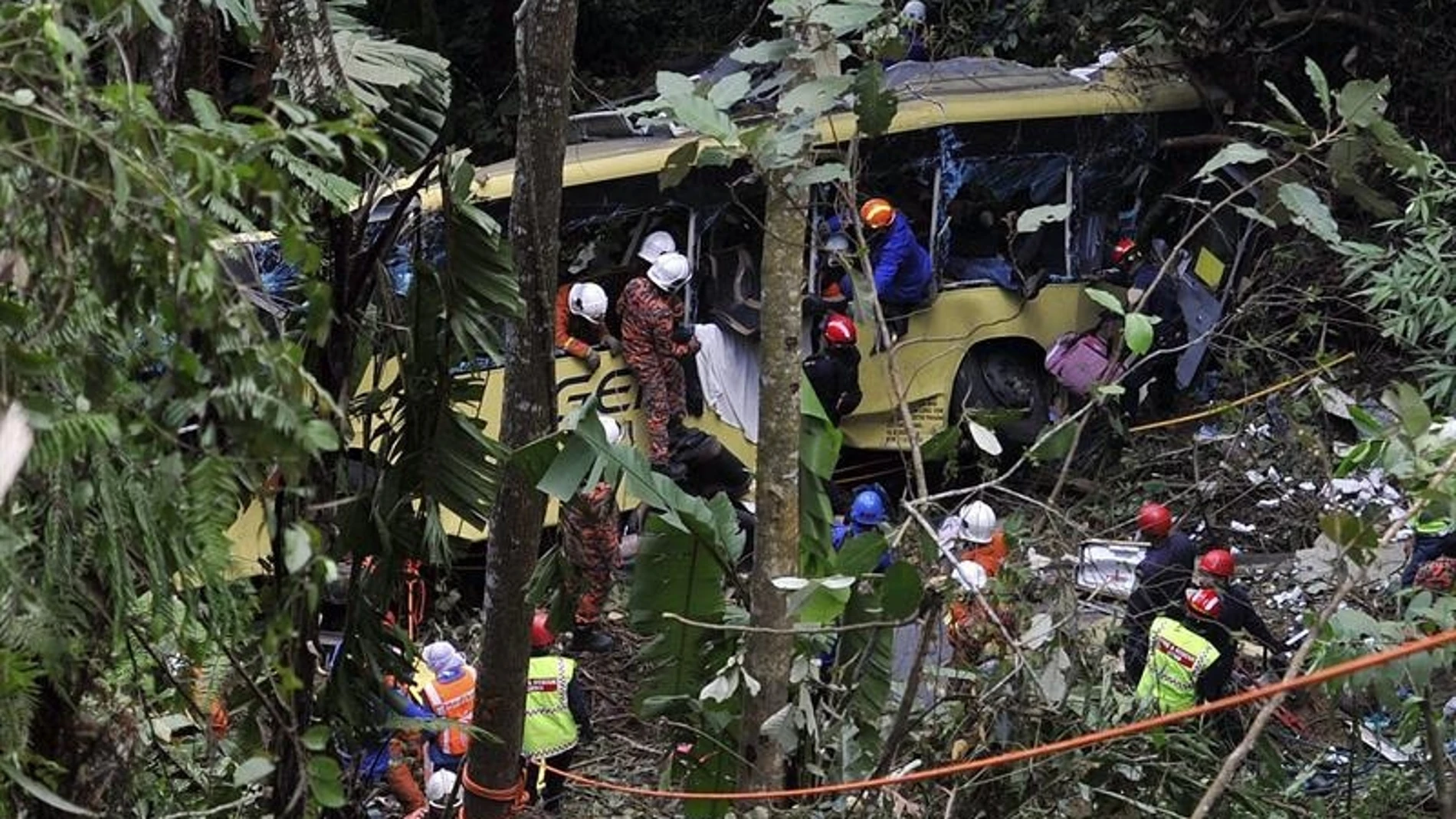Los servicios de emergencias asisten a los heridos del accidente de autobús en Malasia. Los servicios de emergencias asisten a los heridos del accidente de autobús en Malasia.
