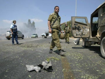 Un soldado israelí camina junto a los restos de un proyectil disparado por los libaneses
