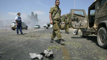 Un soldado israelí camina junto a los restos de un proyectil disparado por los libaneses