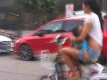 Instantánea de la mujer dando el pecho en un ciclomotor Instantánea de la mujer dando el pecho en un ciclomotor