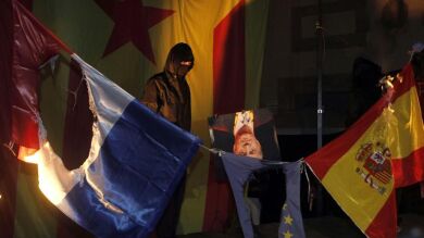 Tres encapuchados queman una bandera de España y un retrato del Rey en Barcelona