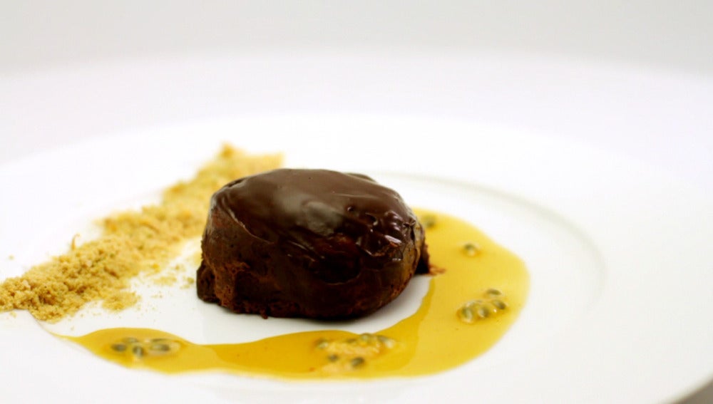 Bomba de chocolate con tierra de curry y salsa de naranja con pimienta rosa