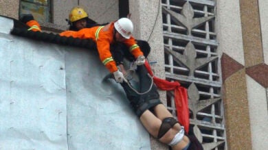 Un chino evita que su esposa se precipite por la ventana agarrándola por una pierna