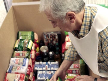 Un voluntario coloca alimentos en una caja