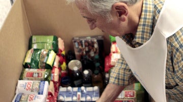 Un voluntario coloca alimentos en una caja