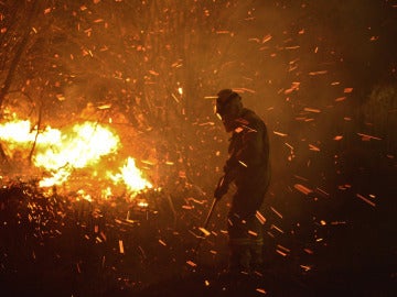 Un operario trabaja para apagar el fuego