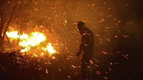 Un operario trabaja para apagar el fuego Un operario trabaja para apagar el fuego