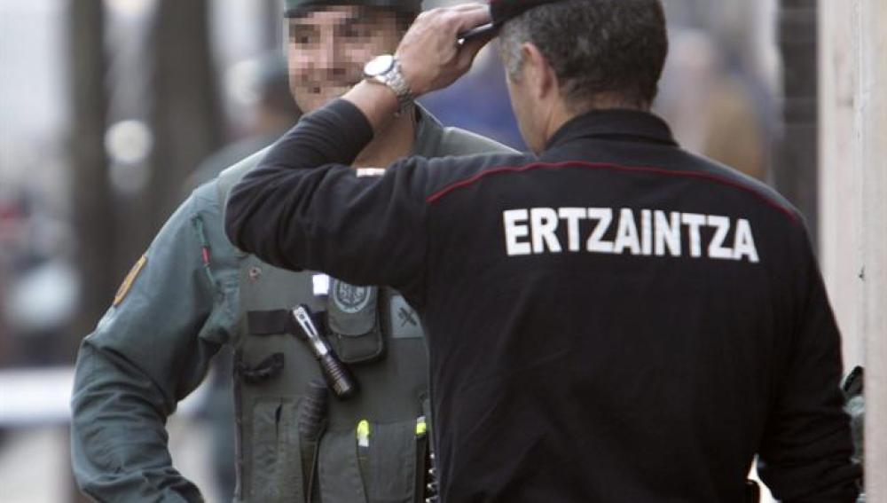 Un agente de la Ertzaintza y uno de la Guardia Civil donde tiene su despacho el senador de EH Bildu