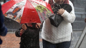 Una señora y un niño bajo la lluvia