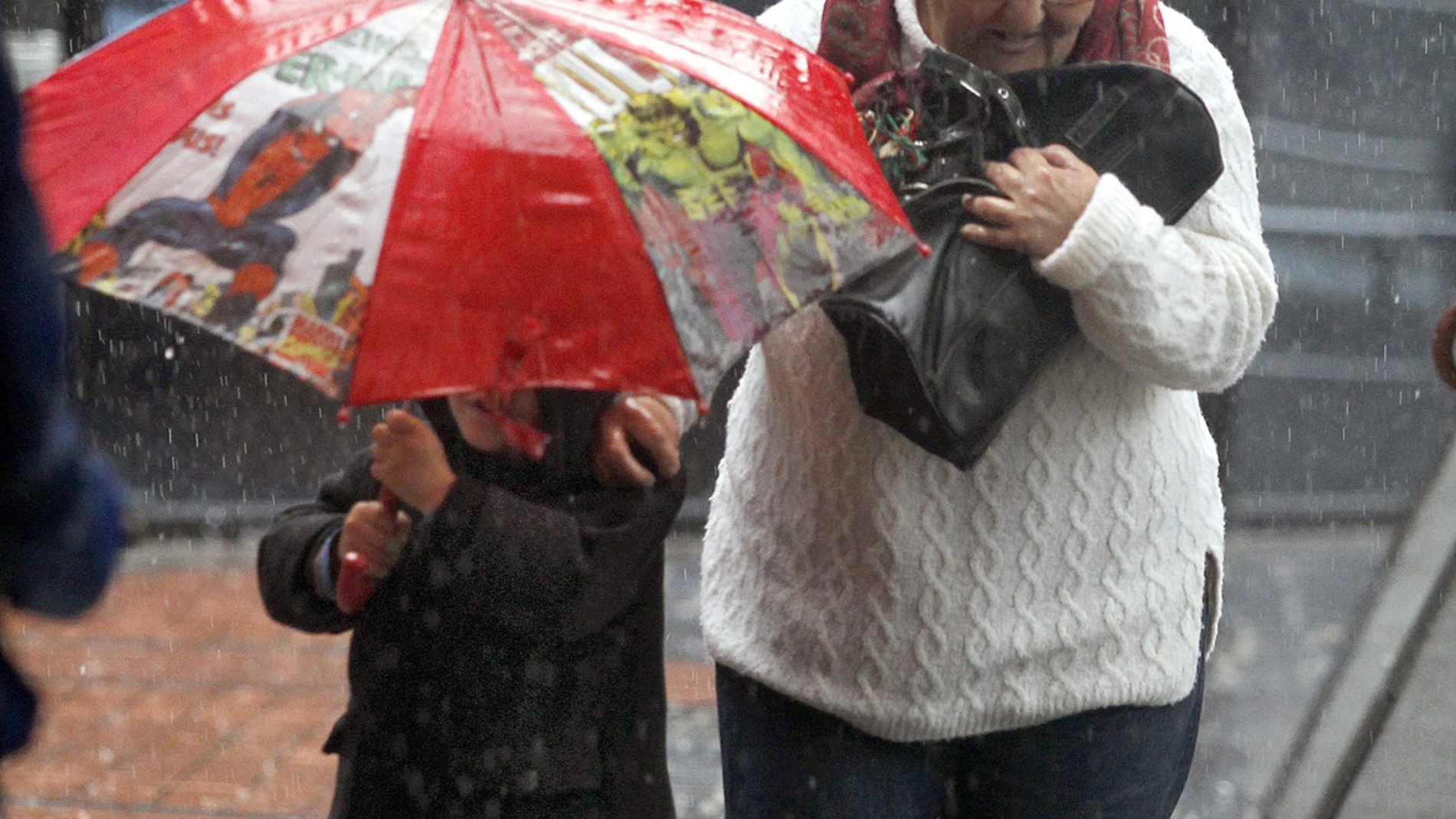 Una señora y un niño bajo la lluvia Una señora y un niño bajo la lluvia