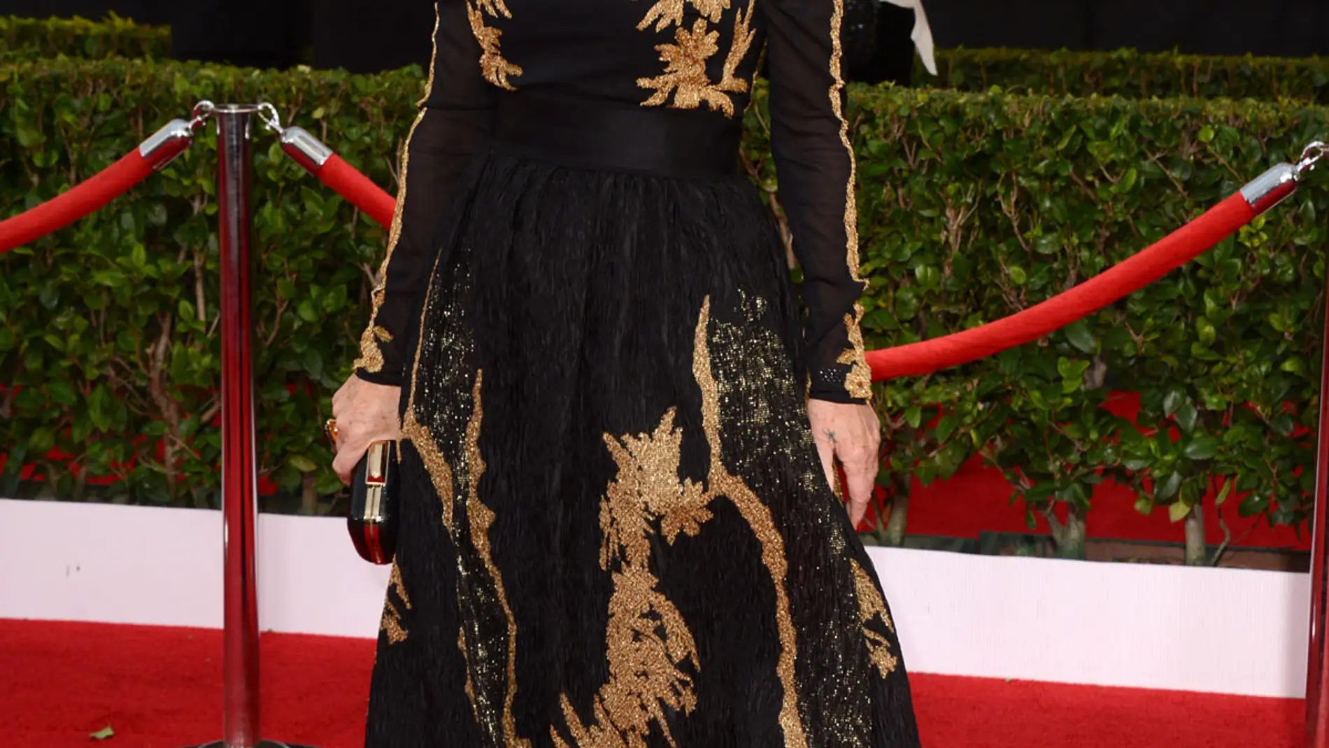 Una elegante Helen Mirren, con vestido largo en negro y dorado