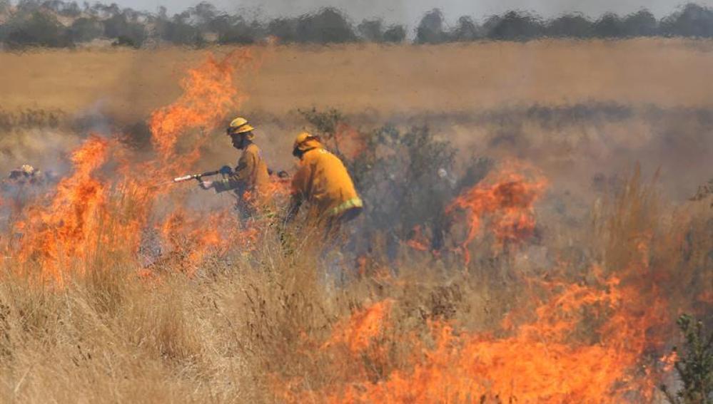 Bomberos en medio de las llamas