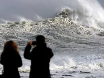 Dos personas fotografían el fuerte oleaje Dos personas fotografían el fuerte oleaje